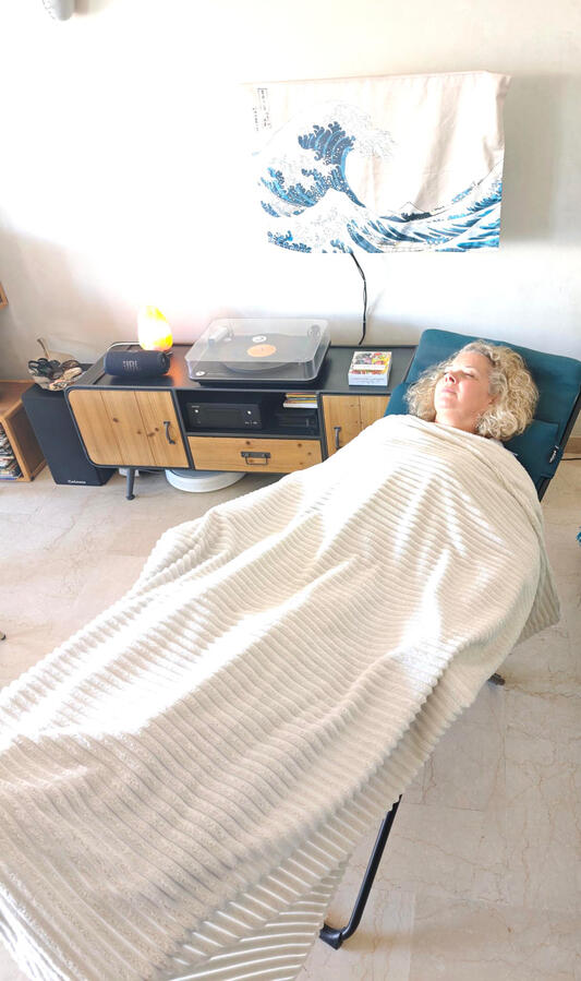 Expérience de séance énergétique profond en cabinet Soul Shiner Consultante recevant une séance énergétique dans le fauteuil de relaxation Soul Shiner